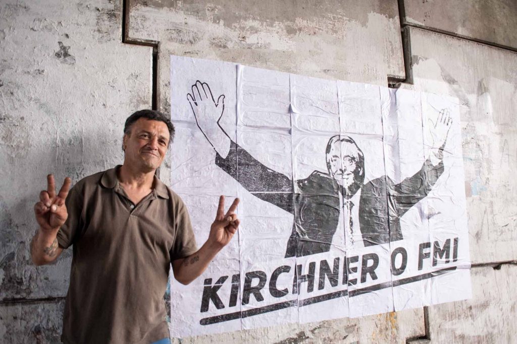 hombre parado junto a un afiche político
